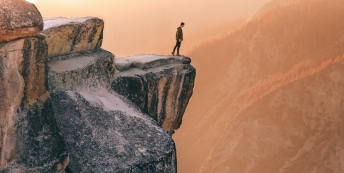 Image of person peering over cliff edge