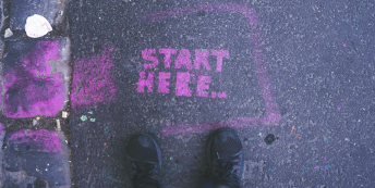 Image of Start Here painted on a pavement