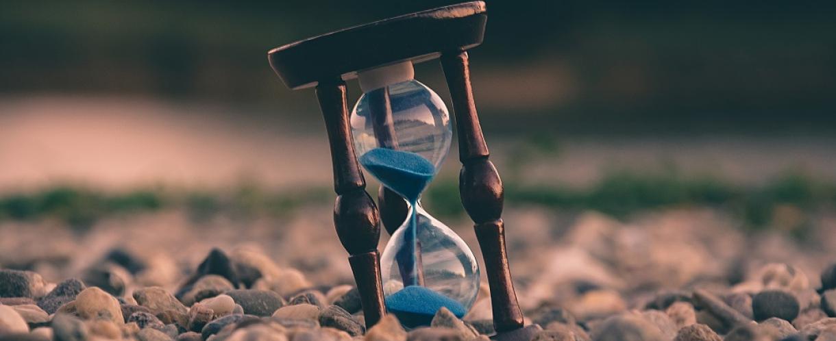 Image of hourglass amongst pebbles