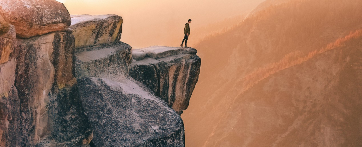 Image of person peering over cliff edge