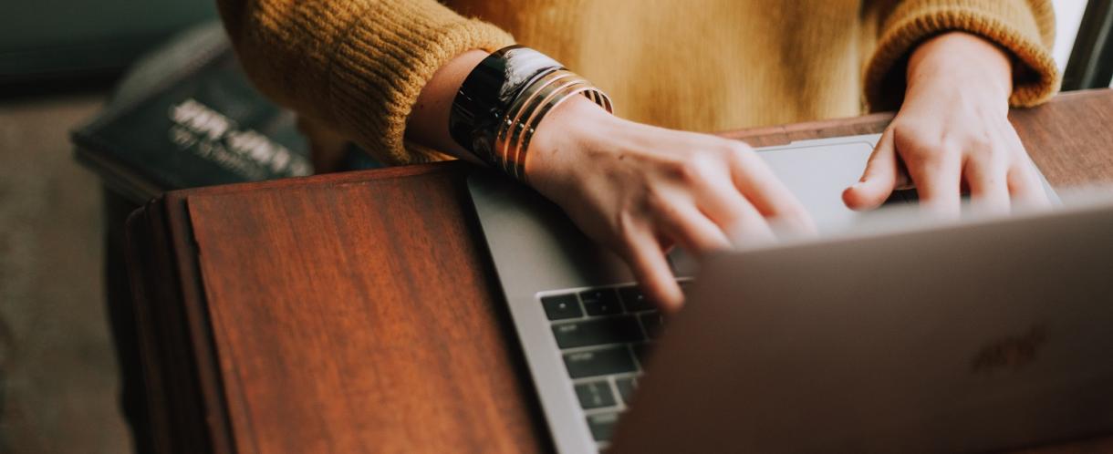 Image of person writing at laptop