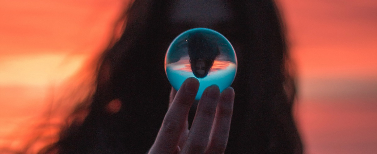 Image of woman holding a glass ball at sunset