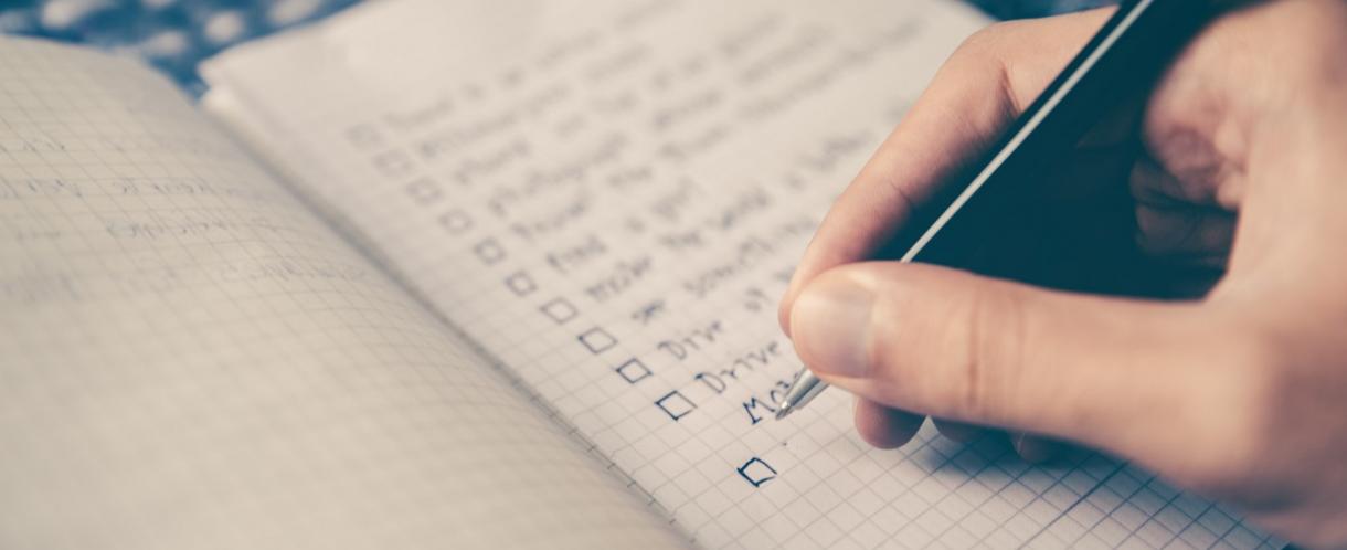 Image of person's hand writing a goal checklist