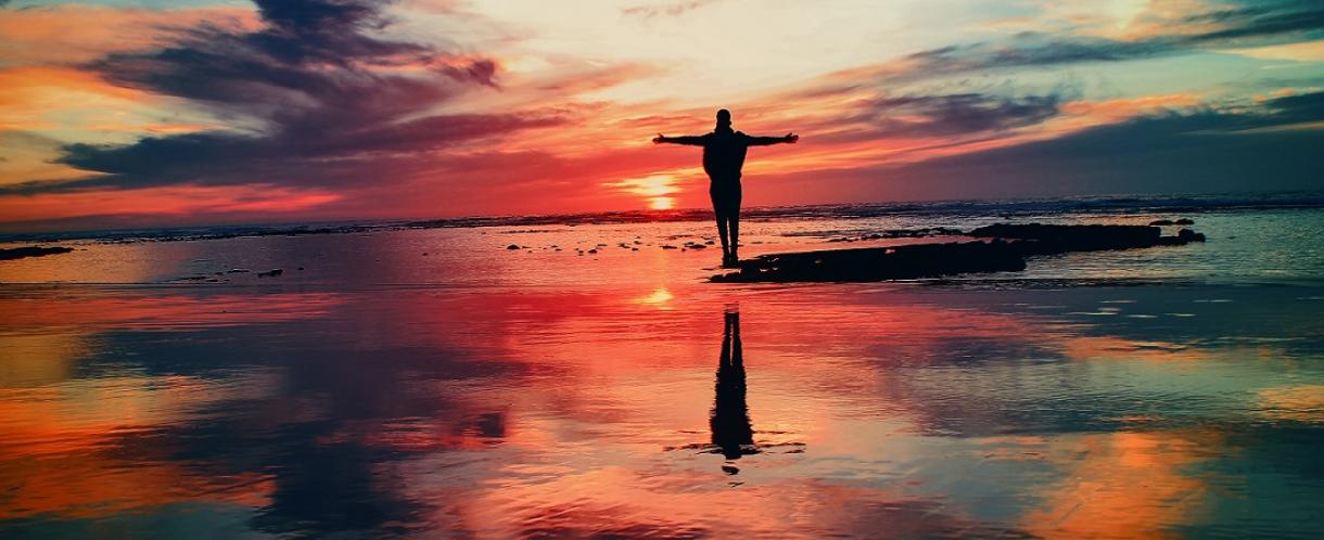 Image of person standing in front of a sunset
