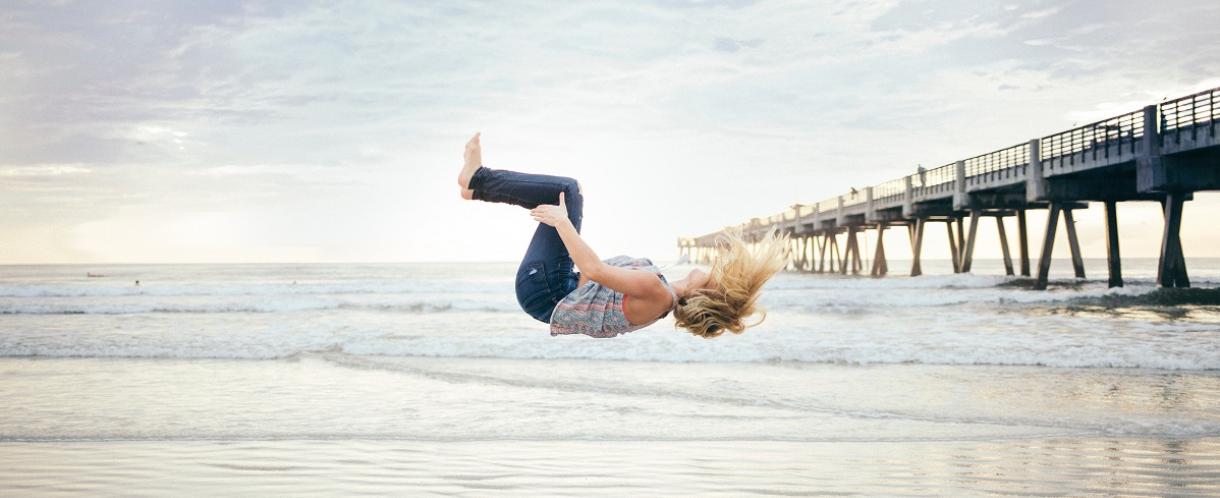 Image if woman mid-jump on a beach